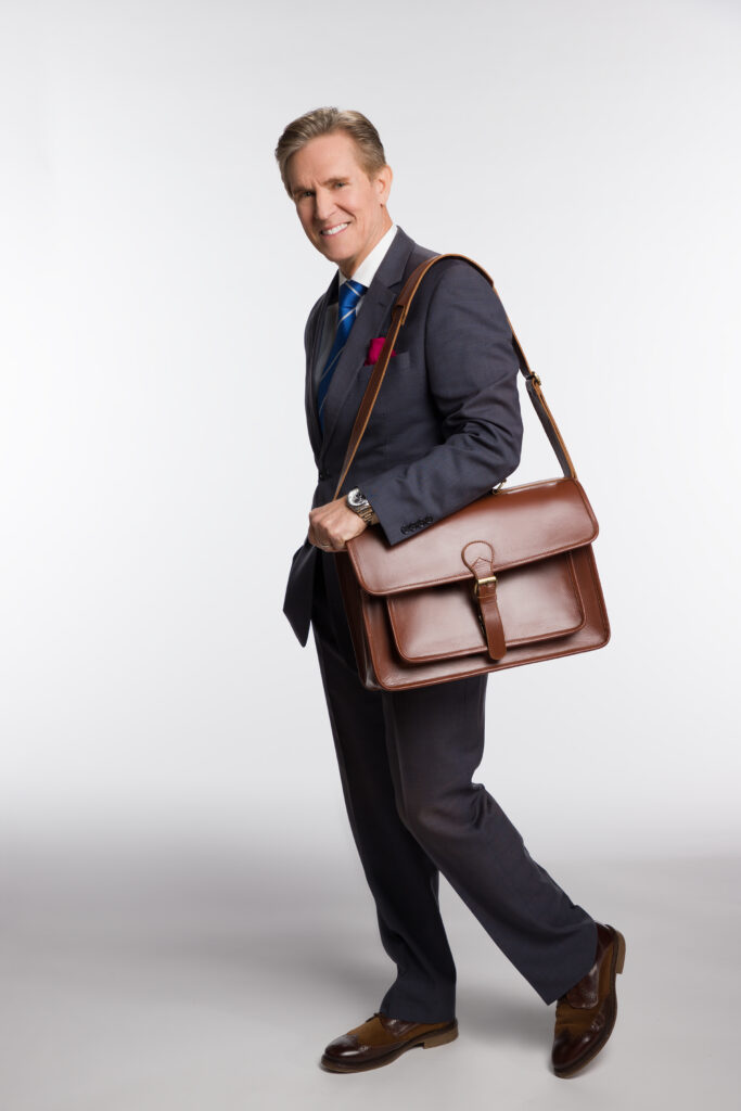 A professional man in a dark suit, walking with a Kriterion Leather briefcase over his shoulder